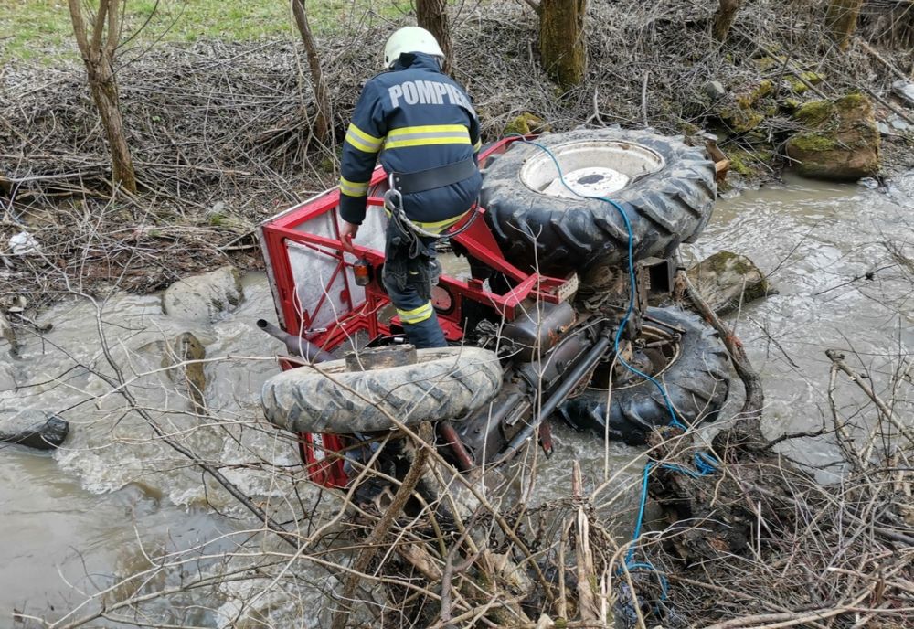 Trei bărbaţi răniţi după ce s-au răsturnat cu tractorul într-un pârâu